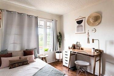 Minimalistisk soveværelse med et skrivebord og gråbeige accenter