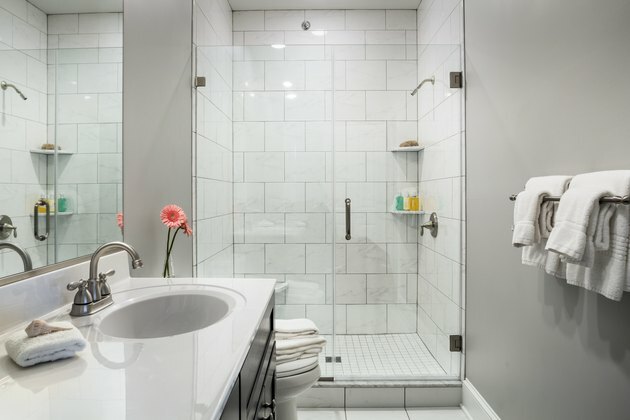 Interior do banheiro com chuveiro e tinta cinza