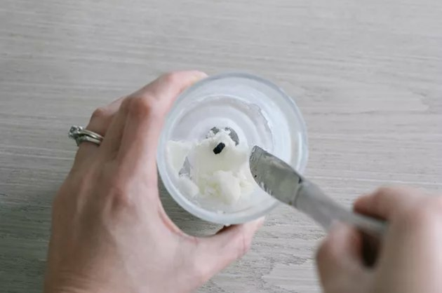 cera sendo raspada do frasco da vela usando uma faca de manteiga