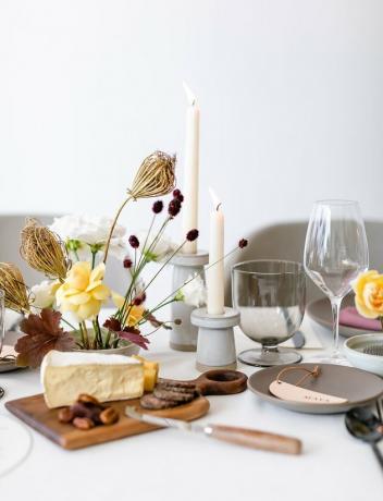 Minimalistisch herfststuk met gedroogde bloemen naast de kaasplank