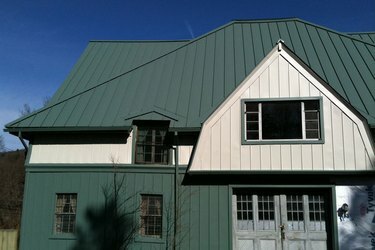 dom z zielonym dachem i zielono-białymi ścianami zewnętrznymi