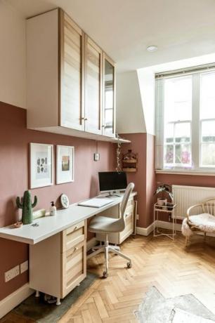 home office moderno com paredes em blocos de cores rosa e móveis de madeira clara