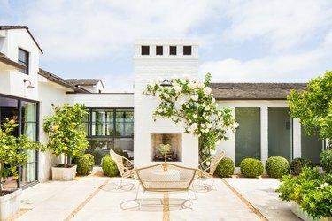 idea di decorazione della nonna costiera per patio incorniciato da piante in vaso