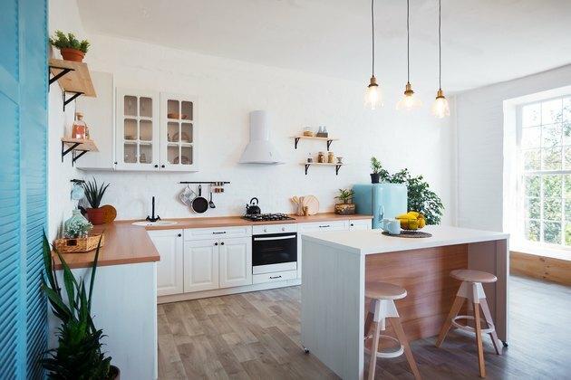 Modern konyha belső, sziget, mosogató, szekrények és nagy ablak új luxus otthonban.