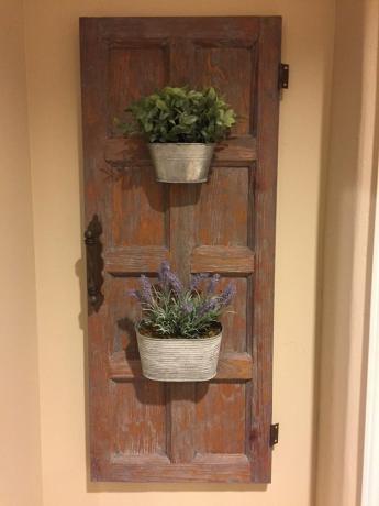 Porta do armário de madeira com dois plantadores galvanizados