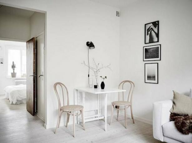 eethoek in de woonkamer wit twee houten stoelen en witte tafel