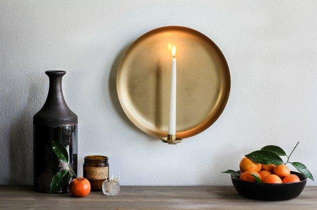 Arandela de parede com vela com tigela de tangerinas e vaso marrom