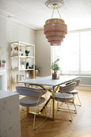 Roze en witte art deco eetkamer met kroonluchter met roze franjes en blauw fluwelen stoelen