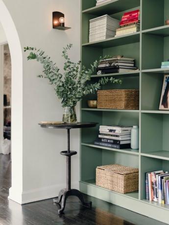 minimalistisch met kleur in witte kamer met groene boekenplank