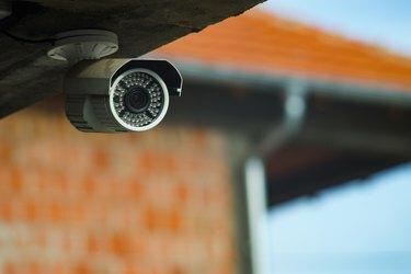 Övervakningskamera under byggnadens betongvägg