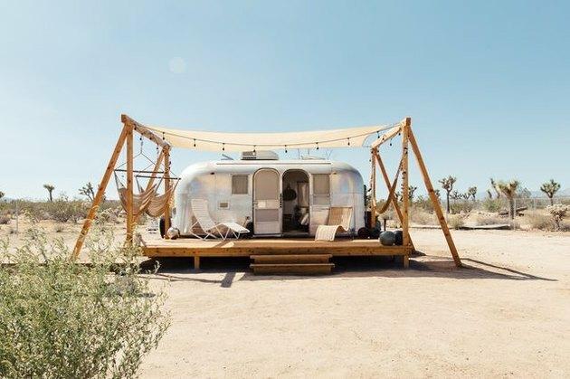 Een veranda met hangstoelen buiten een Airstream