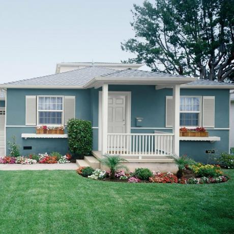 casa exterior cor da casa para 2021 em azul-petróleo com floreiras e flores no jardim da frente