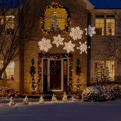 exterieur kerstversiering met traditionele kerstversiering aan de voorkant van de woning met projectie sneeuwvlok lichten.