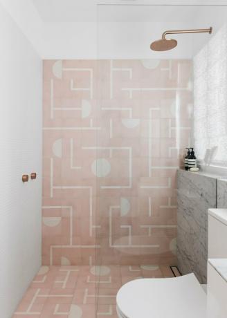 banheiro branco com azulejos estampados rosa no chuveiro