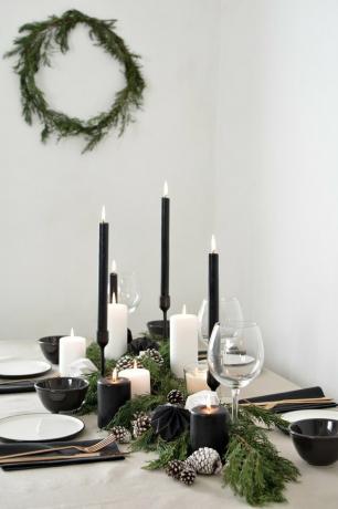mesa branca e preta com velas pretas para a decoração de Natal