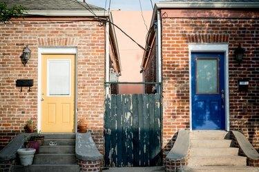 esterno della casa in mattoni rossi con porte d'ingresso colorate