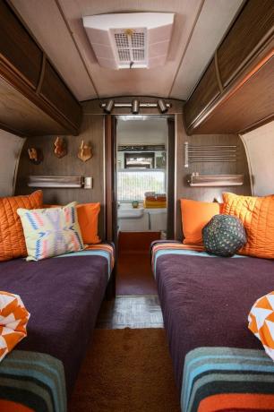 Airstream com roupa de cama roxa e laranja apresentando cores secundárias