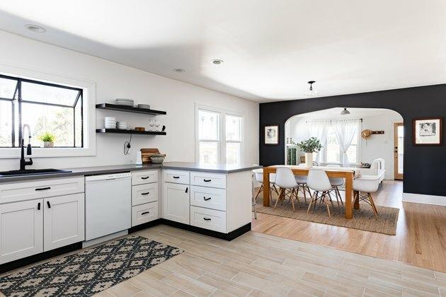 ideia de decoração de parede de sala de jantar para cozinha branca com armários branco-preto e piso de madeira