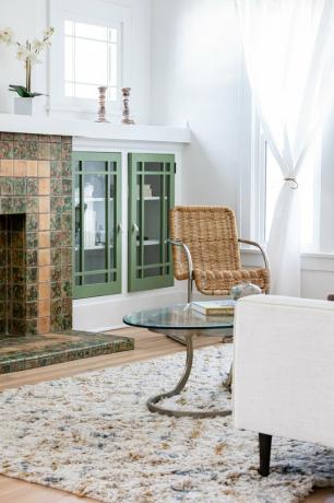 Sala de estar contemporânea com lareira de azulejos, piso de madeira e armários verdes