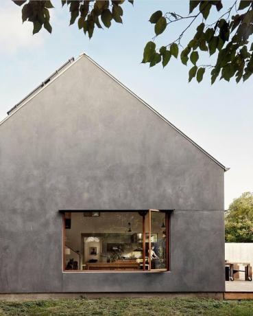 Casa Bauhaus com estética minimalista em carvão e janela aberta