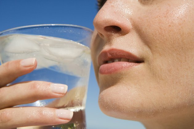 Bicchiere d'acqua bevente della donna