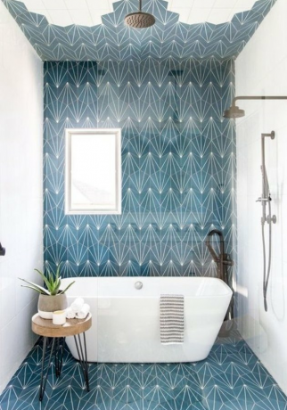 Douche- en badcombinatie in deze badkamer ontworpen door Andrea West Design, met blauwe betonnen tegels op de vloer en muur.