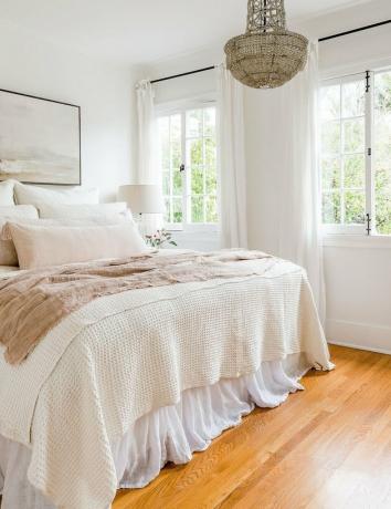 ideia de cor marfim no quarto principal com lustre de cristal e roupa de cama em tons pastel