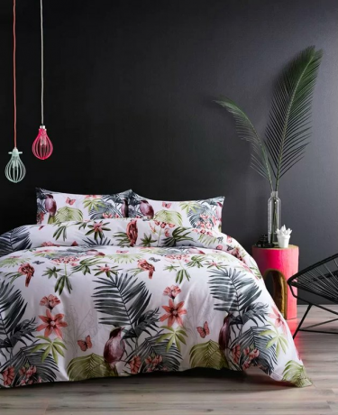 quarto com parede preta e roupa de cama com flores tropicais e padrão de pássaros