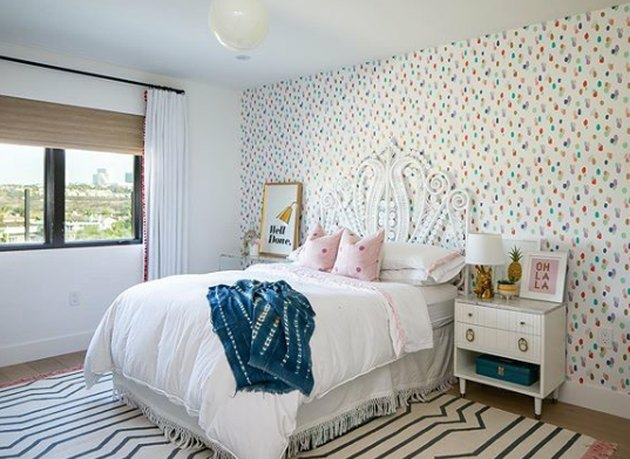 boho meisjeskamer met wit rotan bed en polka dot behang