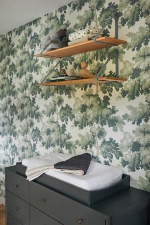 Armazenamento de animais de pelúcia no berçário com prateleiras suspensas e papel de parede projetado por Prospect Refuge Studio