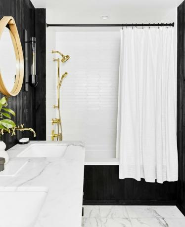 art deco kúpeľňa od Emily Henderson Design s čiernymi stenami a mramorovou podlahou