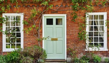 casa in mattoni rossi con porta verde menta