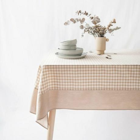 Beige gingham-pöytäliina, joka muistuttaa perinteistä piknikpeitoa. Kivipesty puuvilla antaa sille ikääntyneen ilmeen sekä tonnia korotettua maalaistyyliä.