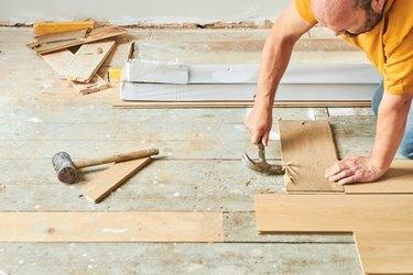 Carpinteiro colocando piso de madeira novo