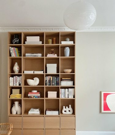 Moderne boekenplank met lades, kunst, boeken, globelamp.