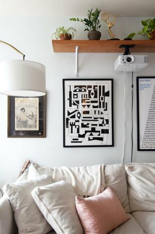Apartamento contemporâneo com arte e prateleiras na parede acima do sofá