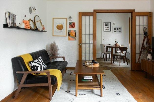 sala de estar com mesa de café de madeira e sofá preto