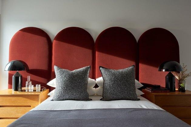 लाल मखमल हेडबोर्ड के साथ बेडरूम