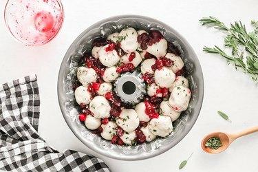 Camada de massa, ervas e molho de cranberry em uma panela Bundt