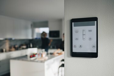 אפליקציית תרמוסטט בטאבלט דיגיטלי המותקנת מעל קיר לבן בבית