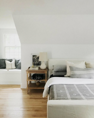 Witte House Seven Design slaapkamer met schuin plafond en gestoffeerd bedframe