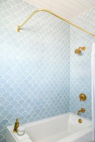 Azulejo azul claro com detalhes em latão no chuveiro