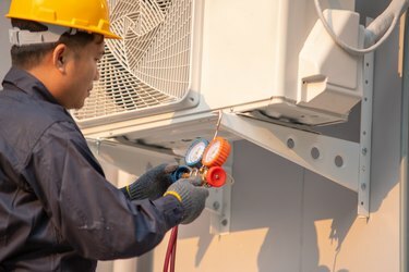 Techniker verwenden Messgeräte zum Befüllen von Klimaanlagen.