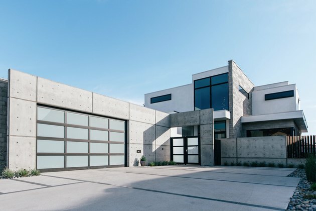 casa de concreto com portas de garagem modernas de vidro e metal