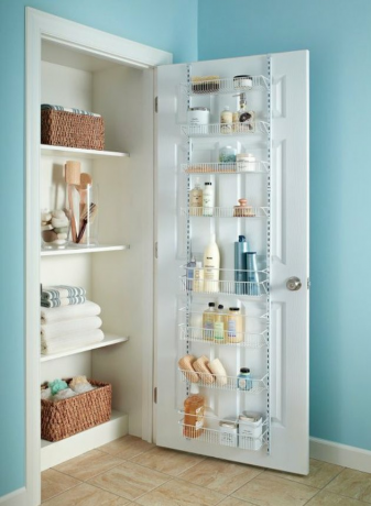 Organizador de armário com roupa de cama, porta com material de limpeza.
