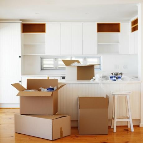 Открытые картонные коробки хранятся на пустой кухне