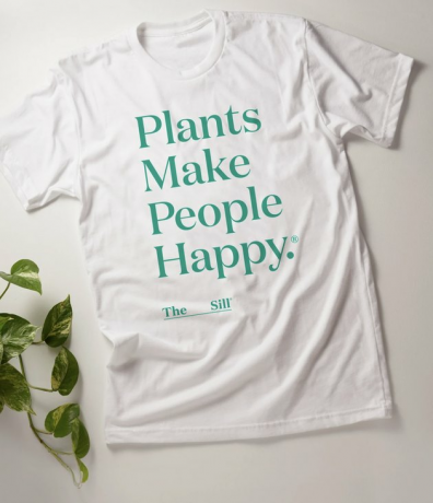 camisa branca com o texto "as plantas fazem as pessoas felizes"