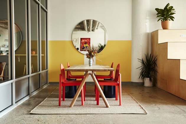 Фотографија жутог простора са црвеним столицама