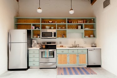 Küche mit blaugrünen Schränken und offenen Regalen