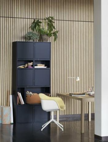 estante azul em estilo cubículo em um escritório de painéis de madeira com mesa e cadeira em estilo escandinavo